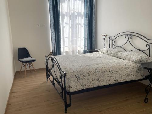 una camera con un letto e una sedia e una finestra di L'Arsenàl a Trieste