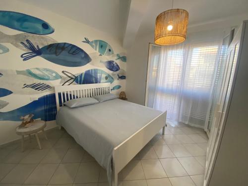 a bedroom with a bed with a fish mural on the wall at Sikuli Home in Oliveri
