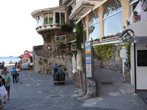 a building on a street with people walking by the ocean at Villa Torre Trasita luxury suites in Positano