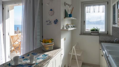 a kitchen with a counter with a sink and a window at Green and Blue vista mare Cala Gonone in Cala Gonone