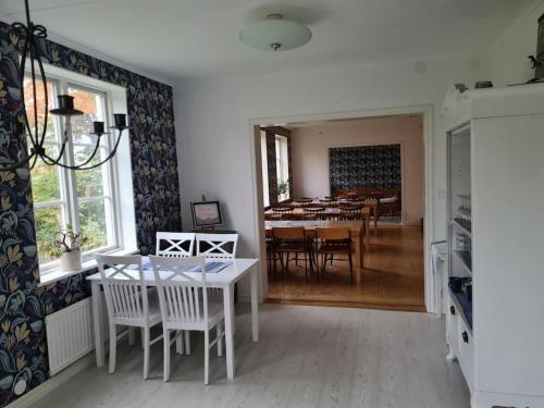 a dining room and living room with a table and chairs at Sörgården - hyr hela gården! (2-35 personer.) in Köping