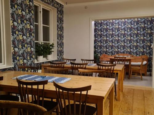 a dining room with wooden tables and chairs at Sörgården - hyr hela gården! (2-35 personer.) in Köping