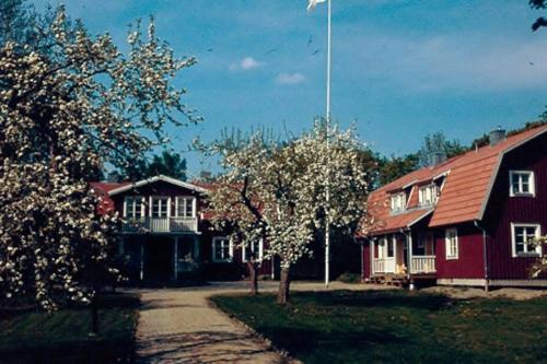 a red house with a flag on top of it at Sörgården - hyr hela gården! (2-35 personer.) in Köping