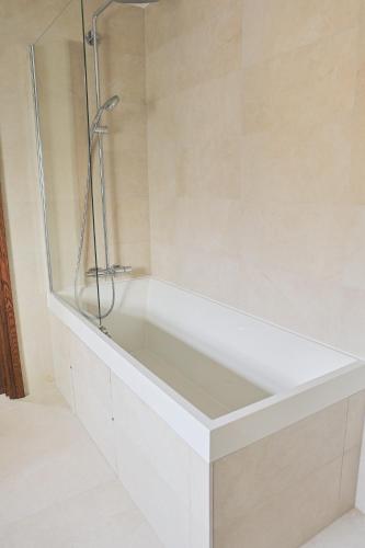 a white bathtub with a glass shower in a bathroom at Up Yonder House - 6 Bedroom Family Guesthouse in Letterkenny