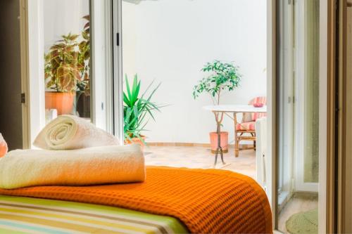 a bed with an orange blanket on it in a room at Renovated, open and functional old city house in Heraklio Town