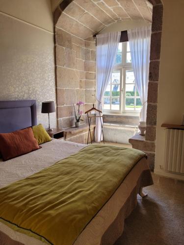 - une chambre avec un grand lit et une fenêtre dans l'établissement Manoir De Keringant, à Saint-Quay-Perros