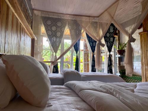 a bedroom with three beds with white pillows at Mount Kilimanjaro 360 view Cottage in Uru