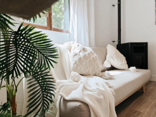 uma sala de estar com um sofá branco e uma planta em Casa Rural Puebla Deluxe em Puebla de Alcocer