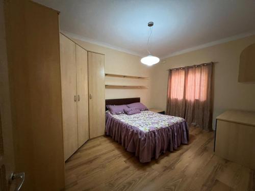 een slaapkamer met een bed met paarse lakens en een raam bij Serene Haven Apartment with three specious bedrooms in Marsaxlokk