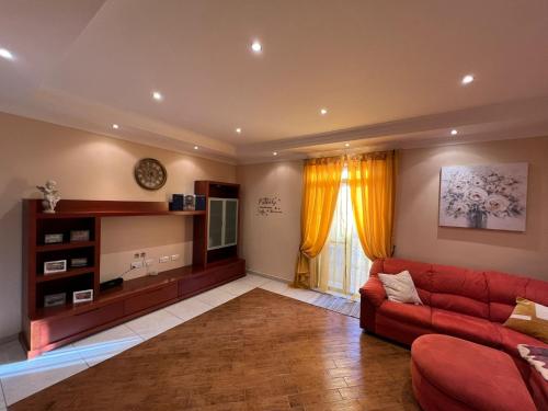 een woonkamer met een rode bank en een televisie bij Serene Haven Apartment with three specious bedrooms in Marsaxlokk