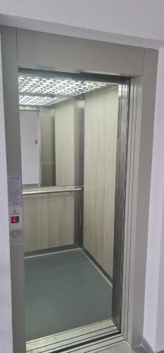 a glass door with a mirror in a bathroom at Apartmani Iva in Banja Koviljača