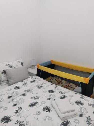 a bedroom with a bed with a black and white blanket at Apartmani Iva in Banja Koviljača