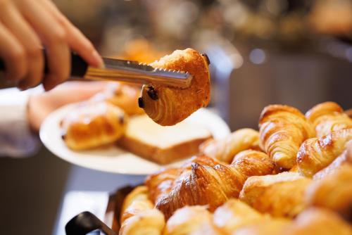 a person is holding a piece of food at Hôtel Restaurant La Vallée Noble, proche Eguisheim Colmar in Soultzmatt