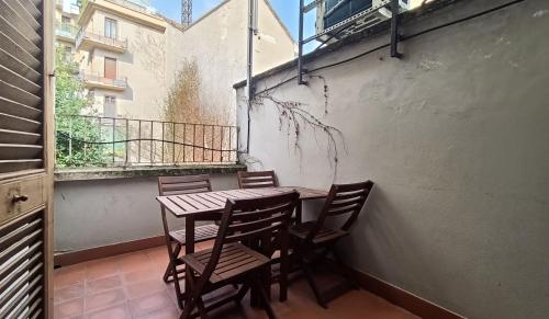a wooden table and chairs on a balcony with a table at SAHI - Residenza Bianca di Savoia in Milan