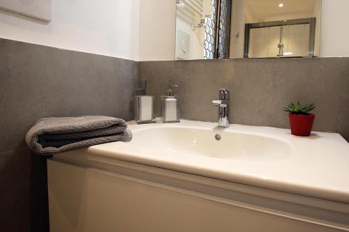 a bathroom with a white sink and a mirror at SAHI - Residenza Bianca di Savoia in Milan