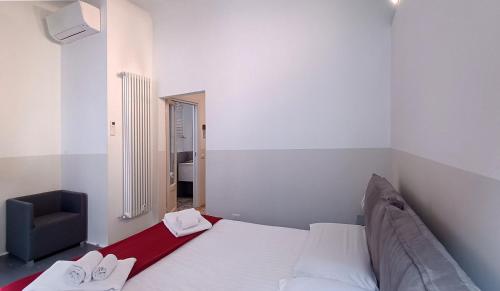 a bedroom with a white bed and a chair at SAHI - Residenza Bianca di Savoia in Milan