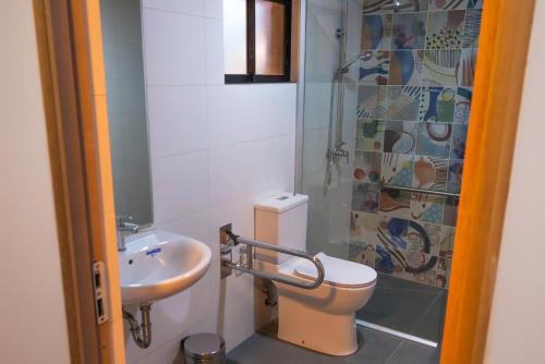 a bathroom with a toilet and a sink at Park Güell House Hotel in Talca