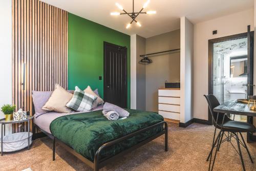 Stunning Central Derby Apartment Free WiFi & Parking في ديربي: غرفة معيشة مع جدار أخضر وأريكة