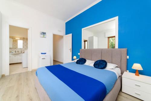a blue bedroom with a large bed and a mirror at Estate4home - Casa Laura in Sant'Agnello