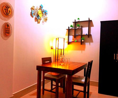 uma sala de jantar com uma mesa com cadeiras e uma luz em JDreamland Homestay em Jorhāt