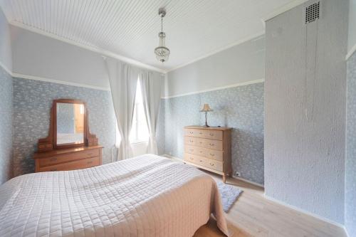 a bedroom with a bed and a dresser and a mirror at Majoitus Wanhapankki, huoneisto B1 in Kalajoki