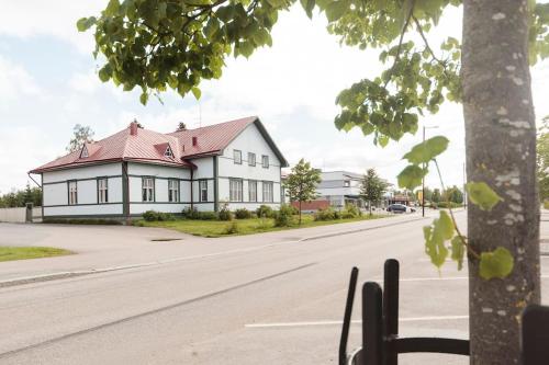 a white house with a red roof on a street at Majoitus Wanhapankki, huoneisto B1 in Kalajoki