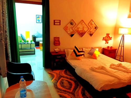 Un dormitorio con una cama y una mesa con una botella de agua. en JDreamland Homestay, en Jorhāt