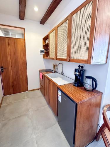 a small kitchen with a sink and a dishwasher at Just Heaven Apartments in Matemwe
