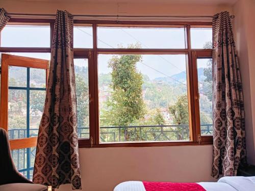 a bedroom with a window with a view at The White House Shimla in Shimla