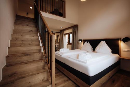 2 Betten in einem Zimmer mit einer Treppe in der Unterkunft FORSTAUERWiRT Hotel & Restaurant in Forstau
