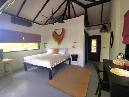 a bedroom with a bed and a dining area and a table at Jade cottages in Koh Samui