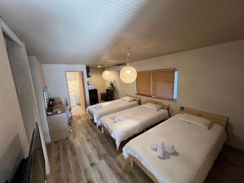 a bedroom with two beds and a chandelier at 大阪京橋_山嵐居102 in Osaka