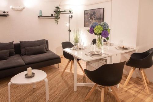 un soggiorno con tavolo e divano di Luxuswohnung mit Kinozimmer im Herzen Berlins BY HOMELY a Berlino