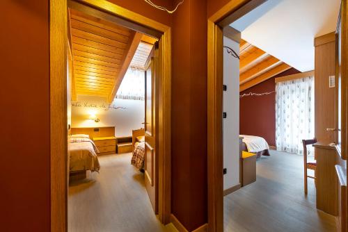 a room with orange walls and a bedroom with a bed at Hotel La Serenella in Moena