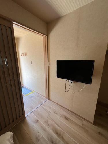 a room with a flat screen tv on a wall at 大阪京橋_山嵐居102 in Osaka