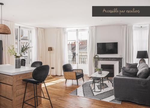 a living room with a couch and a fireplace at Maisons du Monde Hotel & Suites - Nantes in Nantes