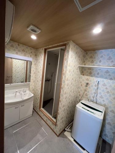 a bathroom with a toilet and a sink and a mirror at 大阪京橋_山嵐居102 in Osaka