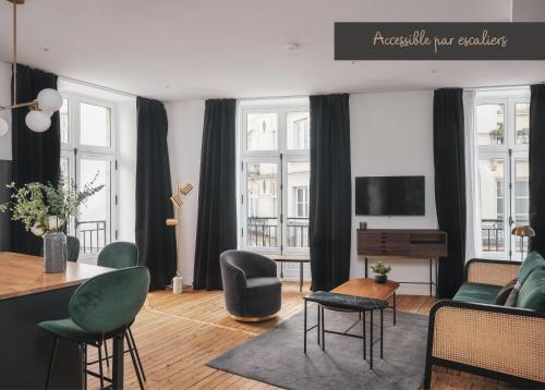 a living room with a couch and a table at Maisons du Monde Hotel & Suites - Nantes in Nantes