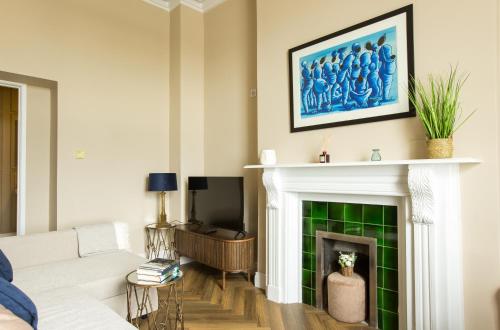 a living room with a white couch and a fireplace at Greystones Harbour Apartments in Greystones