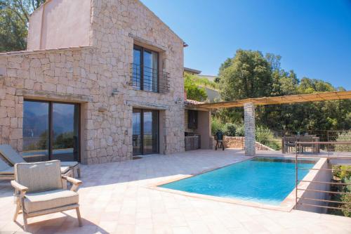 a patio with a swimming pool and a house at Les Demeures de Piana in Piana