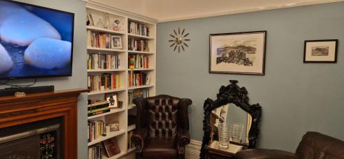 un soggiorno con una tv e uno specchio di Christleton House a Llandudno