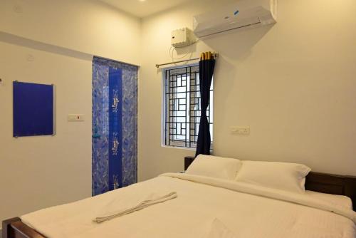 1 dormitorio con cama y ventana en Sea View JC Villa, en Kottakupam