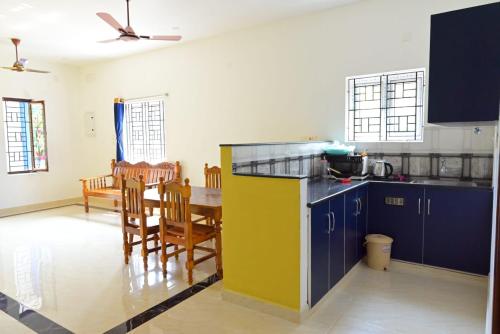 a kitchen and dining room with a table and chairs at Sea View JC Villa in Kottakupam