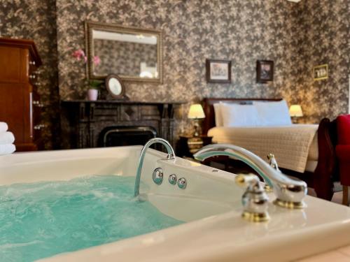 a bathroom with a bath tub with blue water at The Ludington House in Ludington