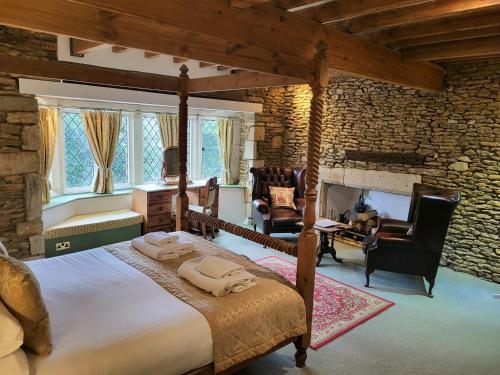 - une chambre avec un grand lit et une cheminée dans l'établissement Swan Inn Lechlade, à Lechlade