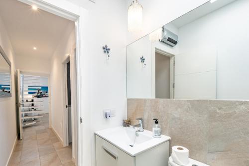 La salle de bains est pourvue d'un lavabo et d'un miroir. dans l'établissement Precioso chalet a pie de playa, à Punta Umbría