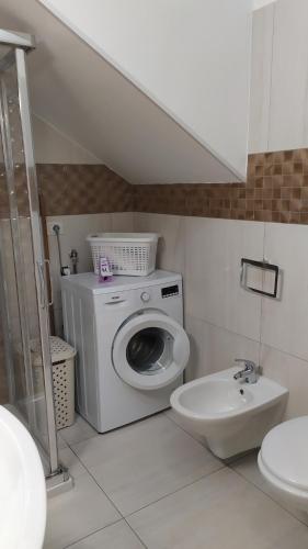une salle de bains avec lave-linge et lavabo dans l'établissement Casa Vacanze STELLA MARINA, à Torre San Giovanni