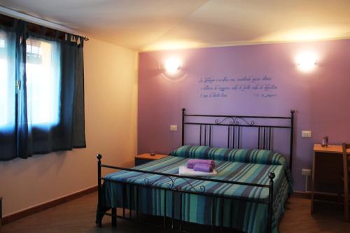 Dormitorio con cama con escrito en la pared en B&B L'alba Nel Golfo, en Castelsardo
