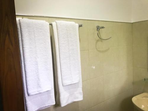 y baño con ducha y toallas blancas. en Kings Villa, en Habarana