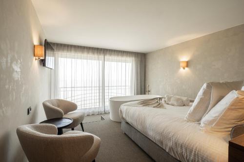 a hotel room with a bed and a bath tub at Hotel Beach Palace by CW Hotel Collection in Blankenberge